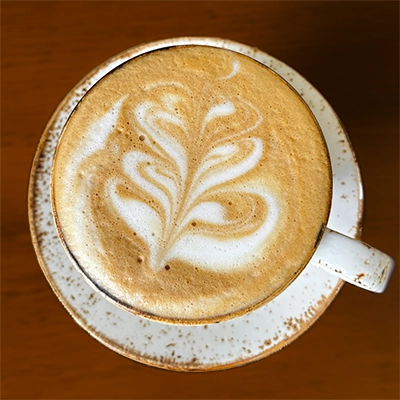 Latte in a cup on a brown table